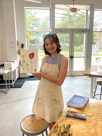 Abigail stands in the Broad Art Lab and holds a painting
