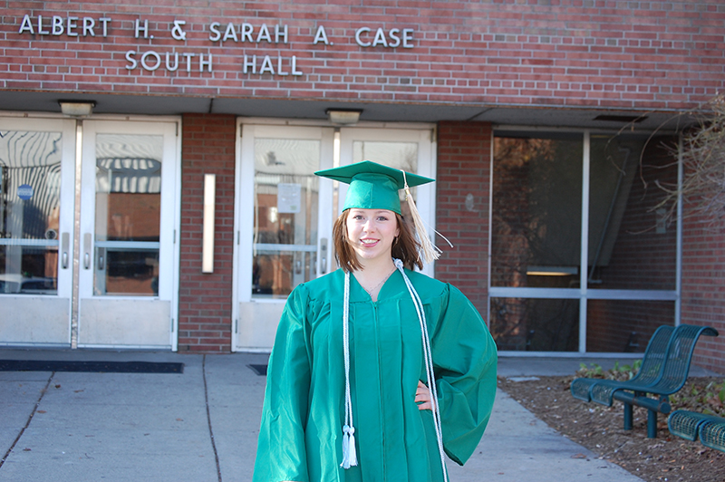 Molly standing in front of Case Hall in cap and gown.