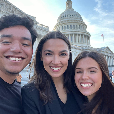 Three people standing together on steps of Capitol